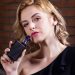 a woman with short blonde hair holding a vape device