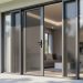Close-up view of a modern home entry with sleek security screen door and stainless mesh panels in front of large glass windows.